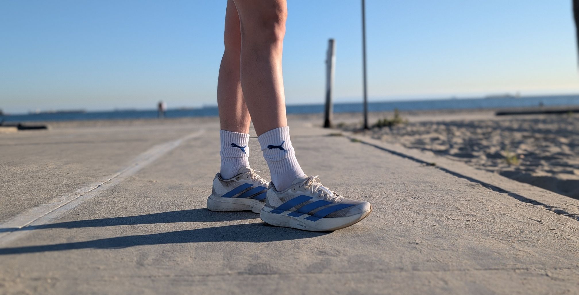 Hannah wearing blue and white running shoes for Our Three Cents Honest Fitness Product Reviews