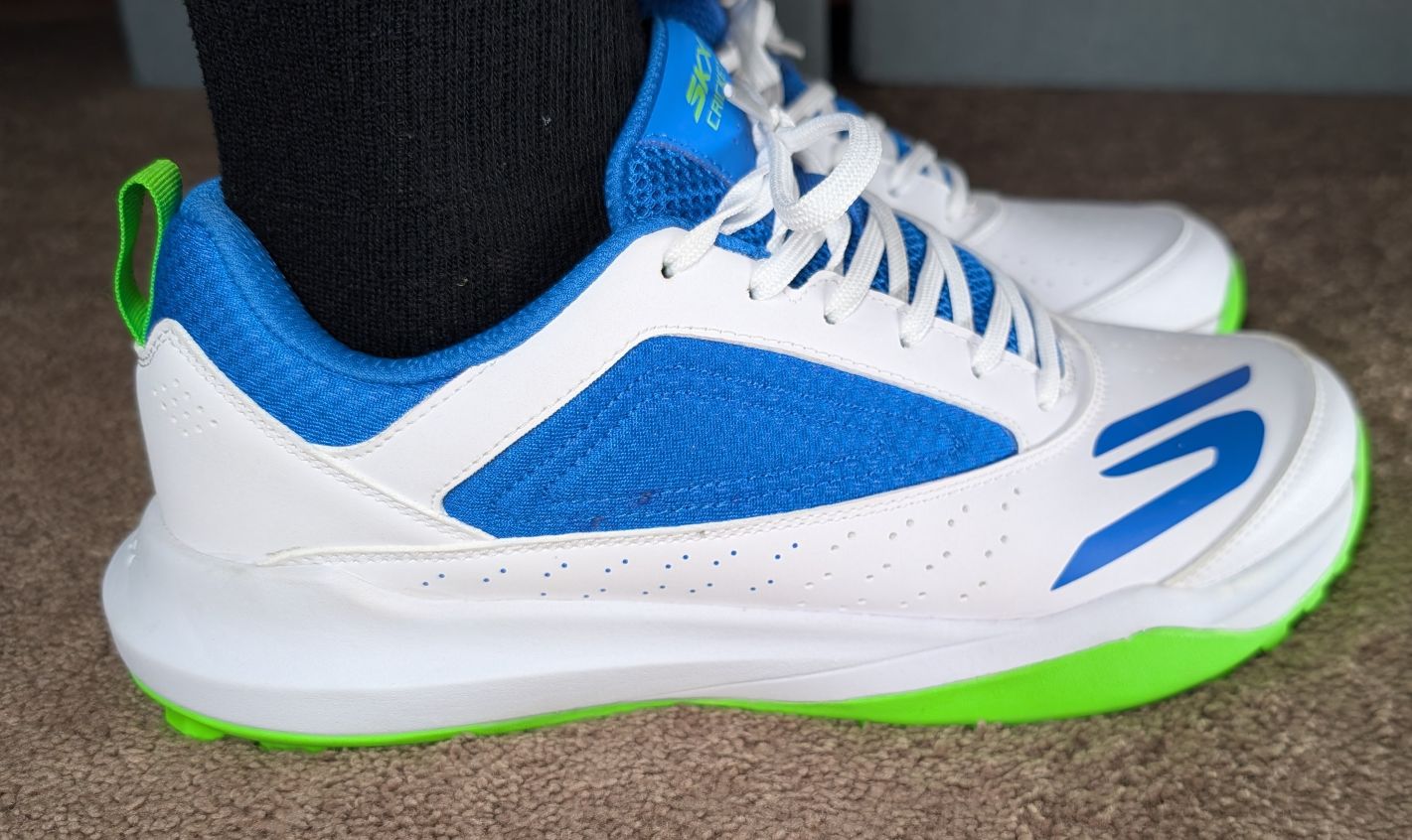 Side view of tight skechers JQ8547 turf cricket shoes on feet