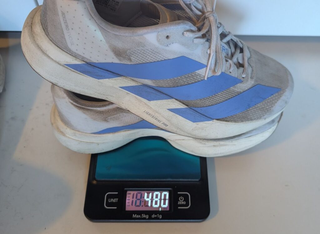 Adidas Adizero EVO SL running shoes stacked on weight scale showing 480 grams