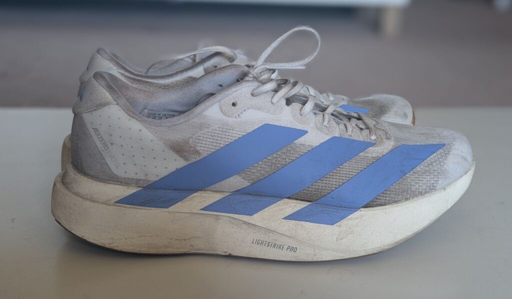 Profile view of the blue three stripes logo on the Adidas Adizero EVO SL running shoes