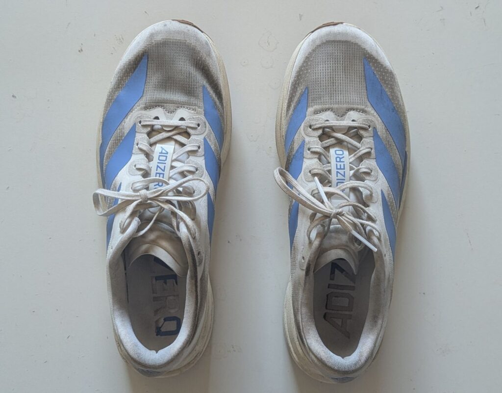 Top-down view of a worn pair of Adidas running shoes in fusion blue and white