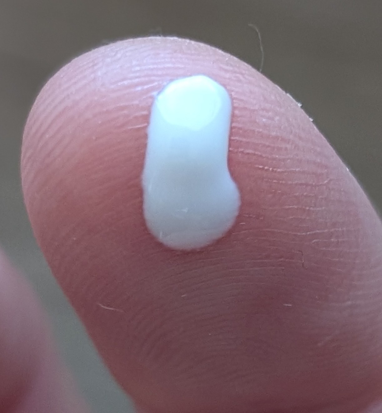 Close up of Aveeno Protect and Hydrate sunscreen white droplet on fingertip.