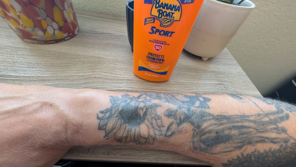 Banana Boat Sport sunscreen applied to sunflower tattoo on arm.