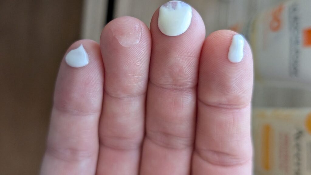Fingertips with Banana Boat Sport, Trader Joe's, La Roche-Posay, and Aveeno Protect and Hydrate Sunscreen to show sunblock consistency.
