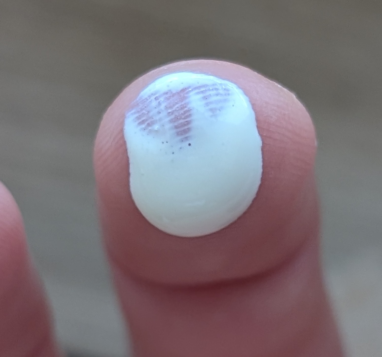 Close up of La Rochey-Posay Anthelios mineral sunscreen white droplet on fingertip.