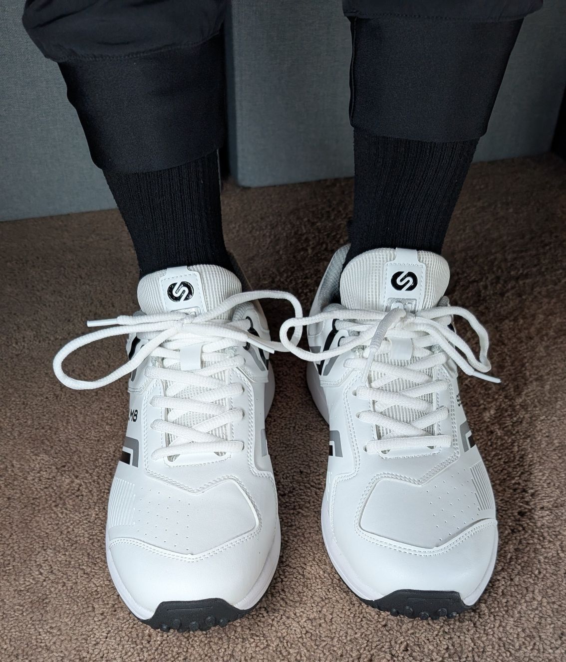 on feet front view of white solm8 s1 rubber spikes shoes