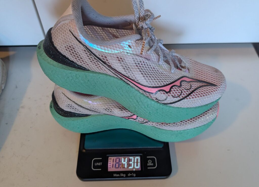 Saucony Endorphin Pro 3 green and pink shoes weighed on scale showing 430 grams