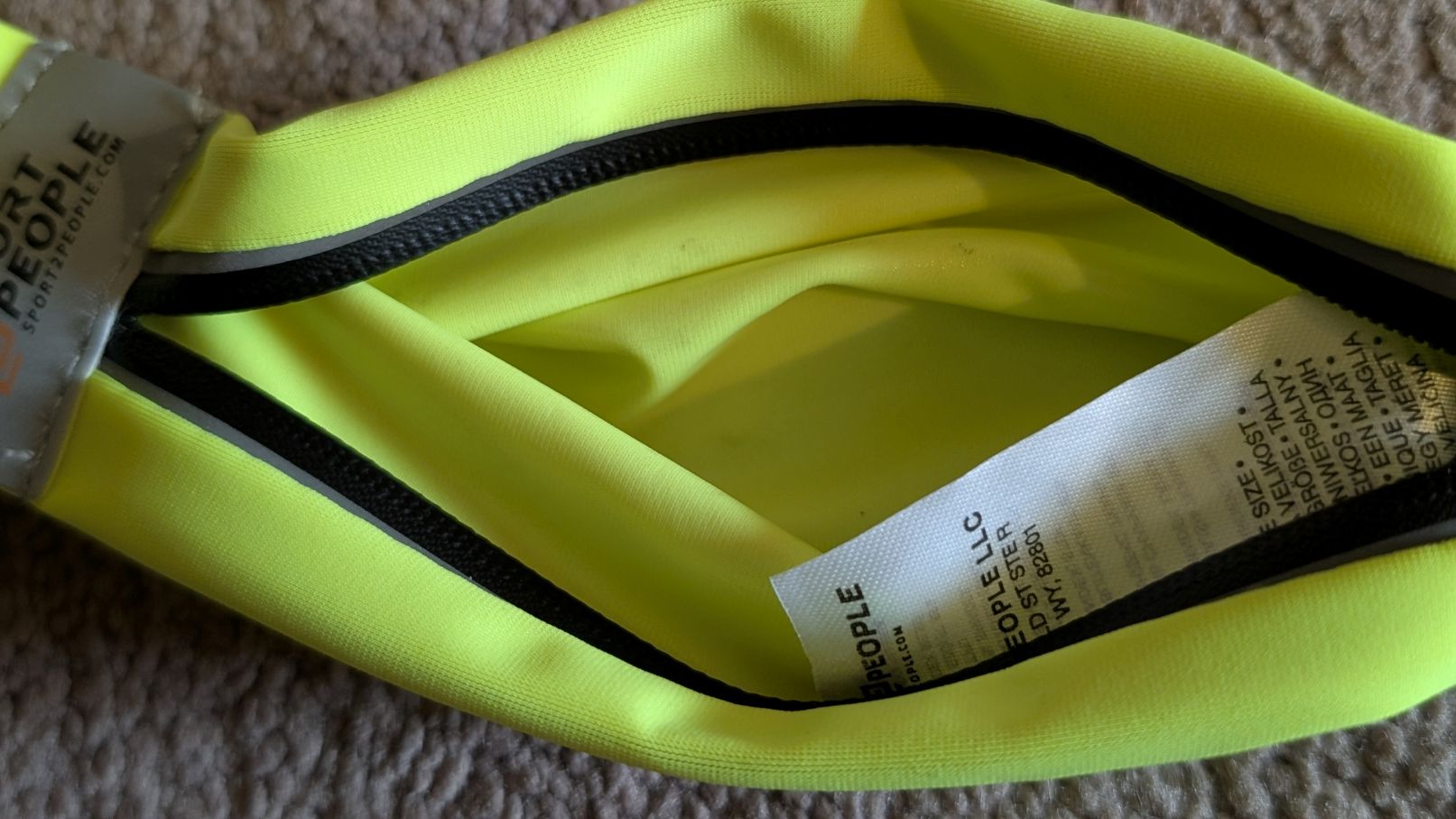 Close up view of inside of TPU-lined small pocket of fluorescent yellow Sport2People running belt