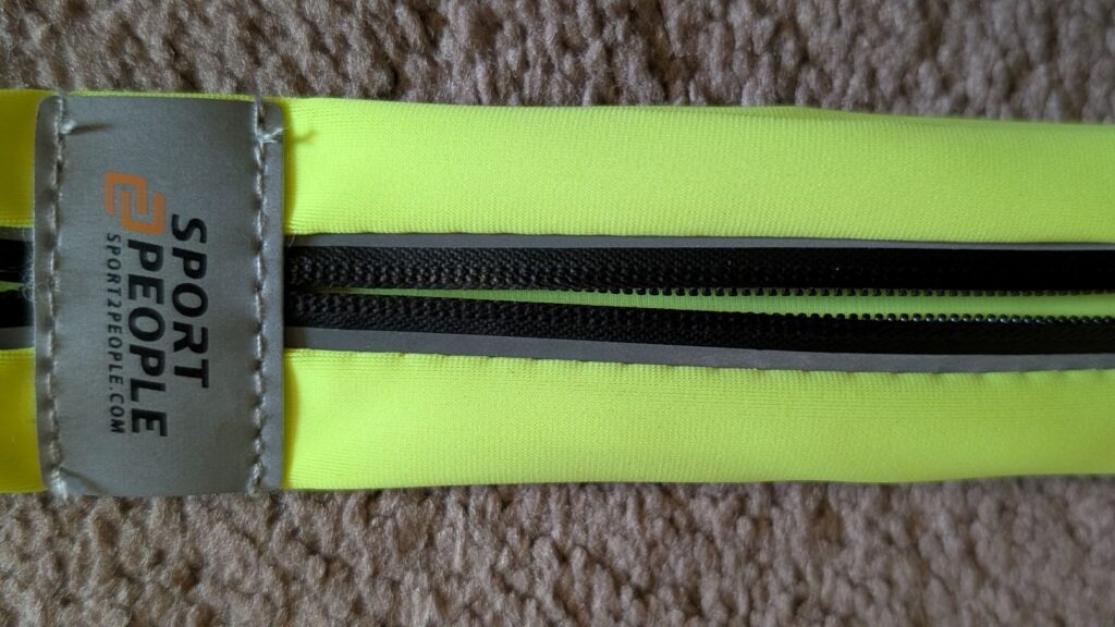 Close up of Sport2People reflective label and darts on yellow running belt