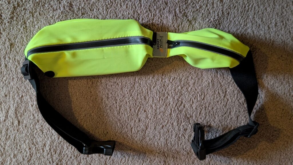 Yellow running belt on floor with both pockets filled