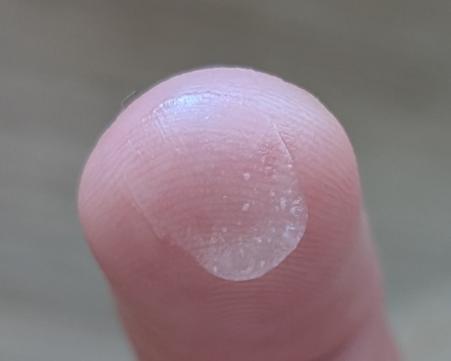 Close up of Trader Joe's Invisible Gel sunscreen clear drop on finger.