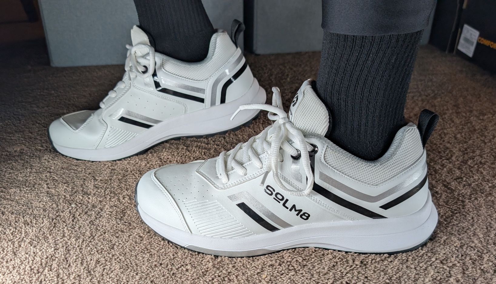 black and white spikeless cricket shoes on feet 