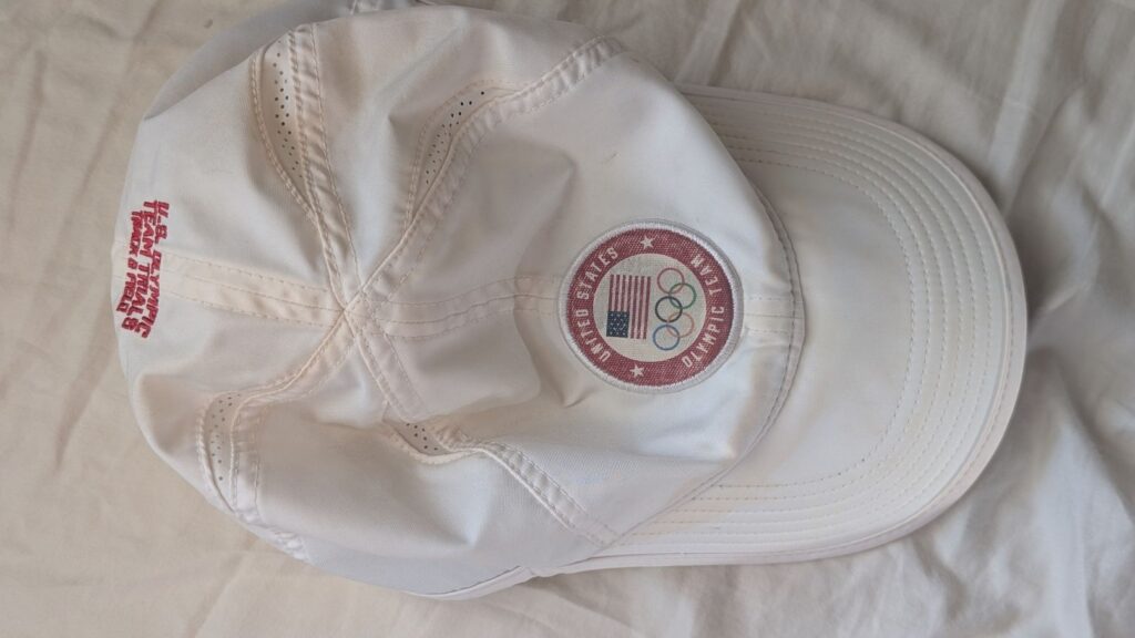 Top-down view of white hat with U.S. Olympic team red logo on the front