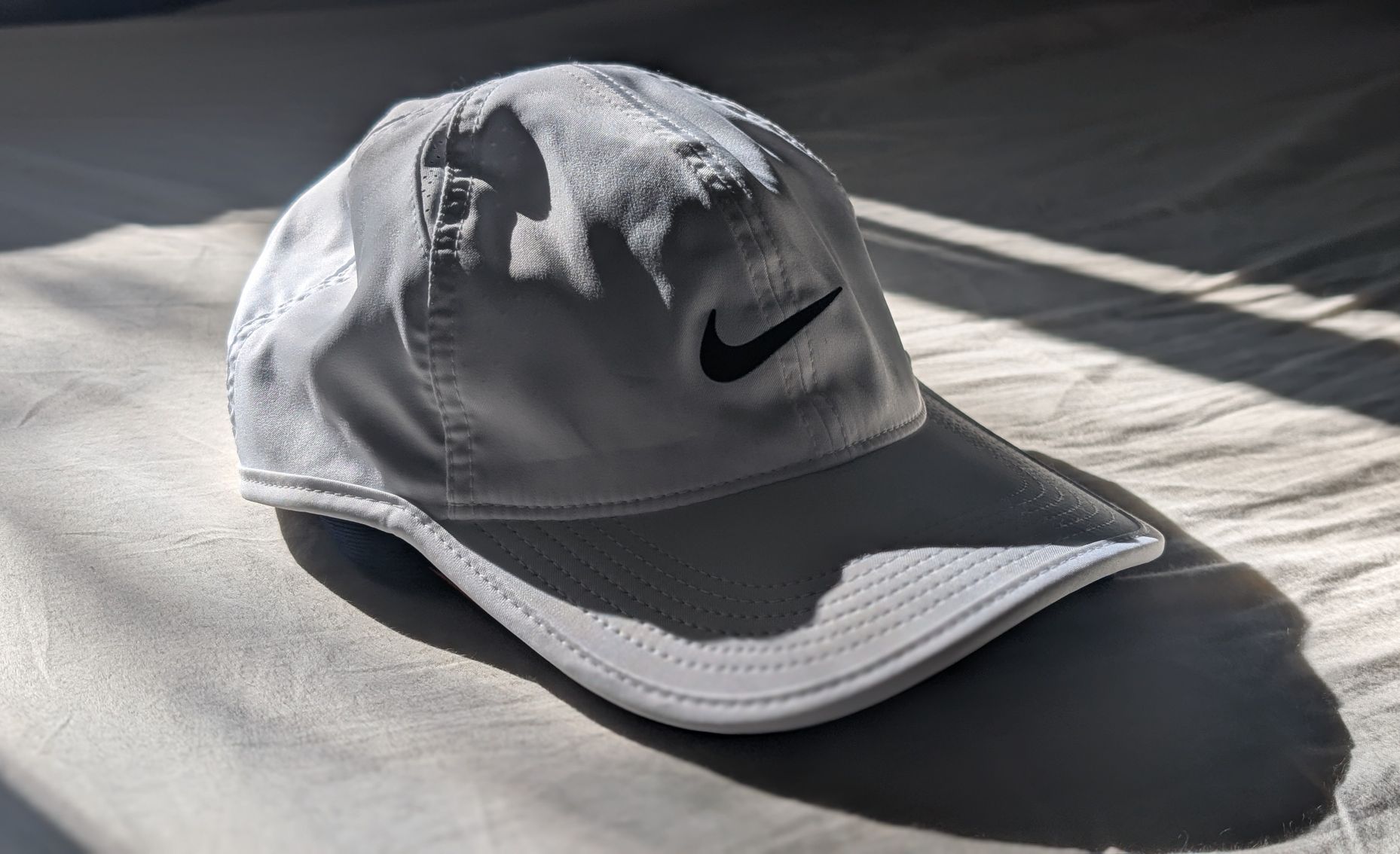 Nike Dri-FIT Club Unstructured Featherlight Cap for runners in white with black logo