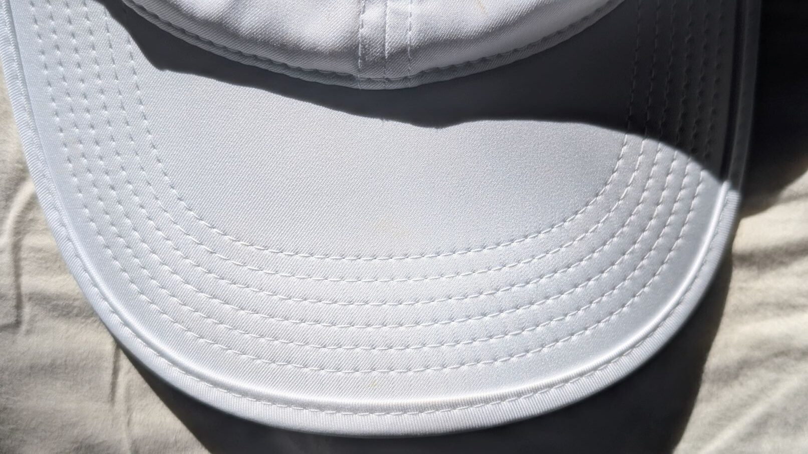 Close up of stitching on white Nike running cap visor