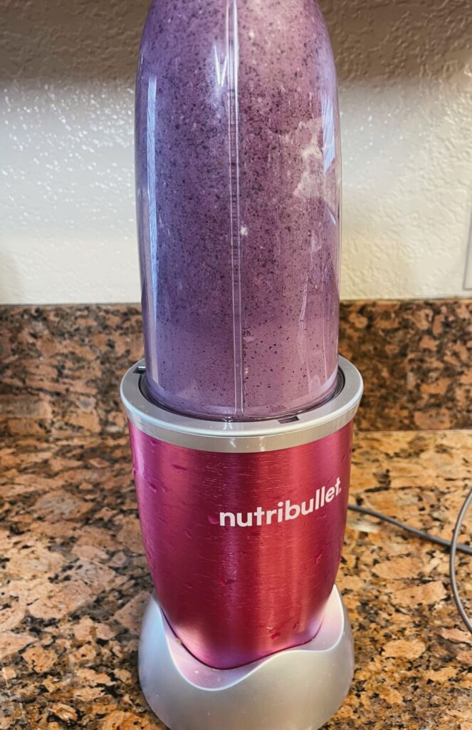 Nutribullet blender with cup filled with blueberry high protein smoothie recipe already blended
