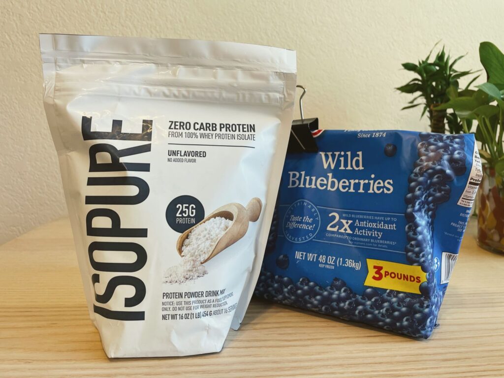 Close up of bag of Isopure zero carb high protein powder and frozen blueberries bag