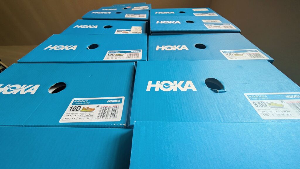 Stack of blue boxes showing prices of Hoka shoes on sale