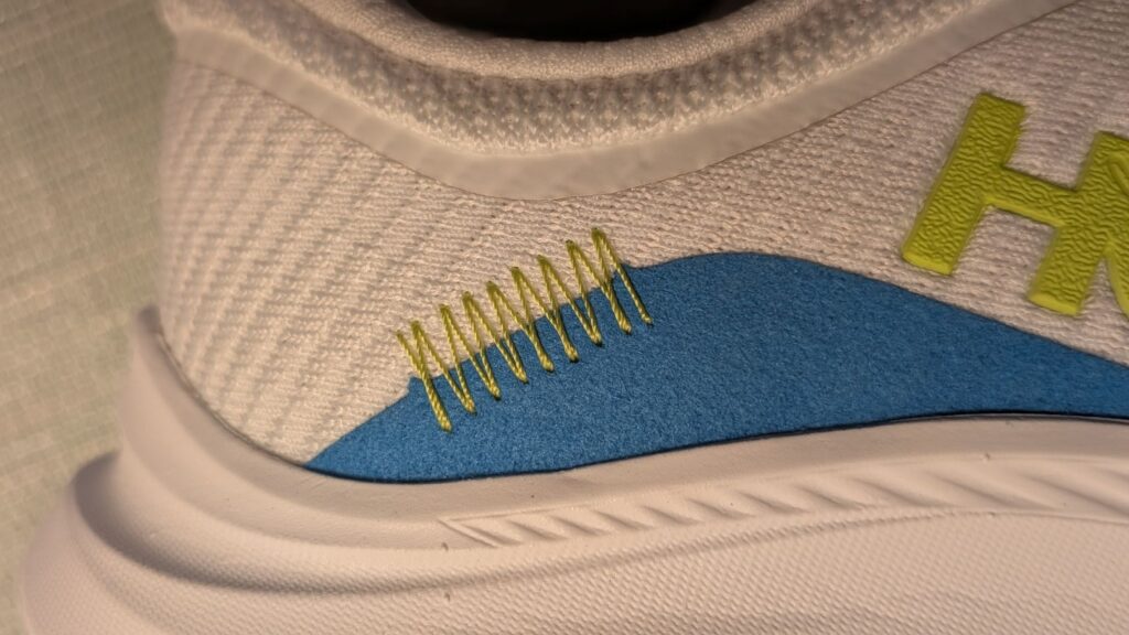 Close up of design elements on Hoka daily trainer in white and blue