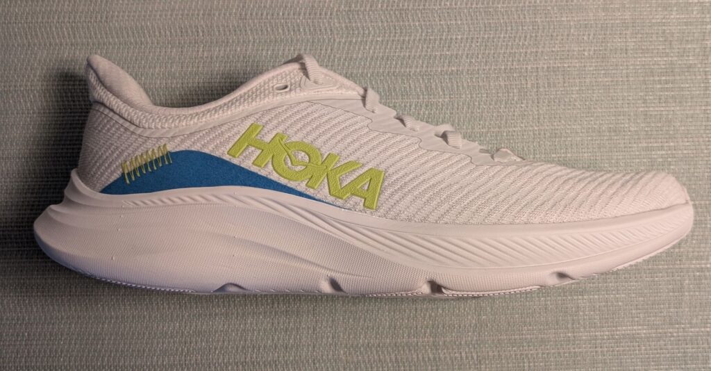 Profile view of Hoka shoe in white, blue, and green