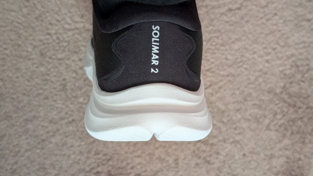 White text showing Solimar 2 printed on back of black running shoe
