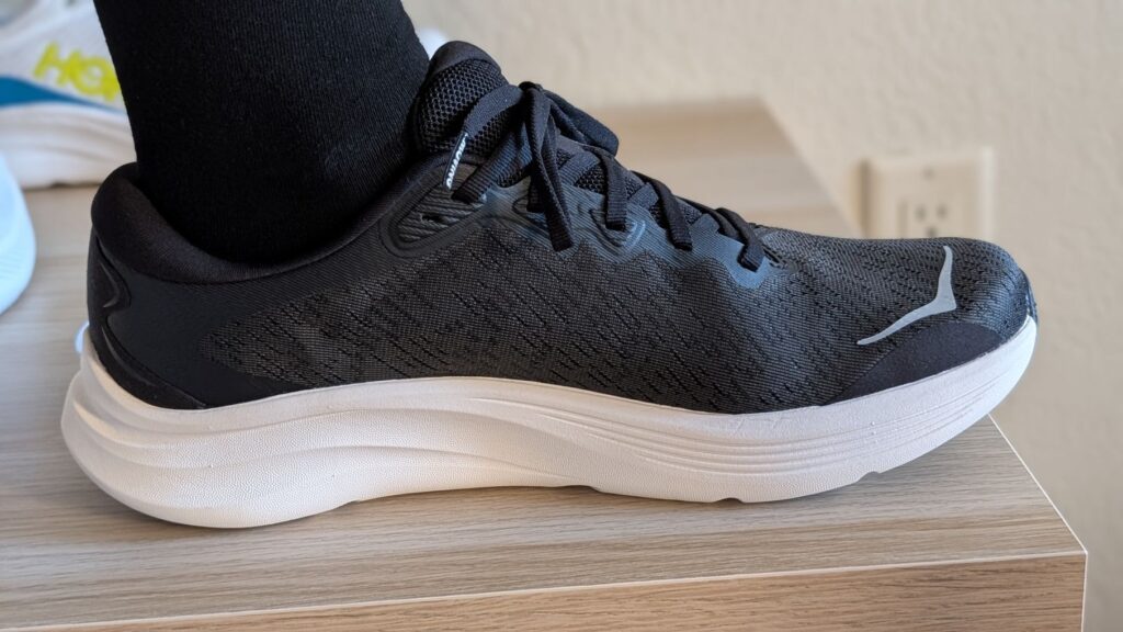 Side view of Hoka Solimar 2 in black and white on foot