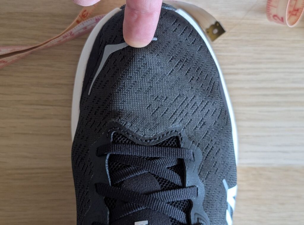 Finger pointing to toe to show length on Solimar 2 10D shoe in black