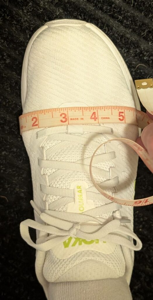 Measuring tape showing 6 inch width on Hoka Solimar white shoe size