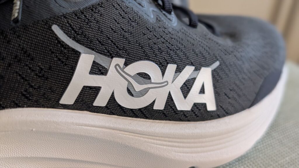 Close up of white and silver logo on Hoka Solimar 2