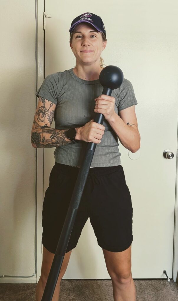 Female cricket player holding 15lb steel mace cricket training equipment