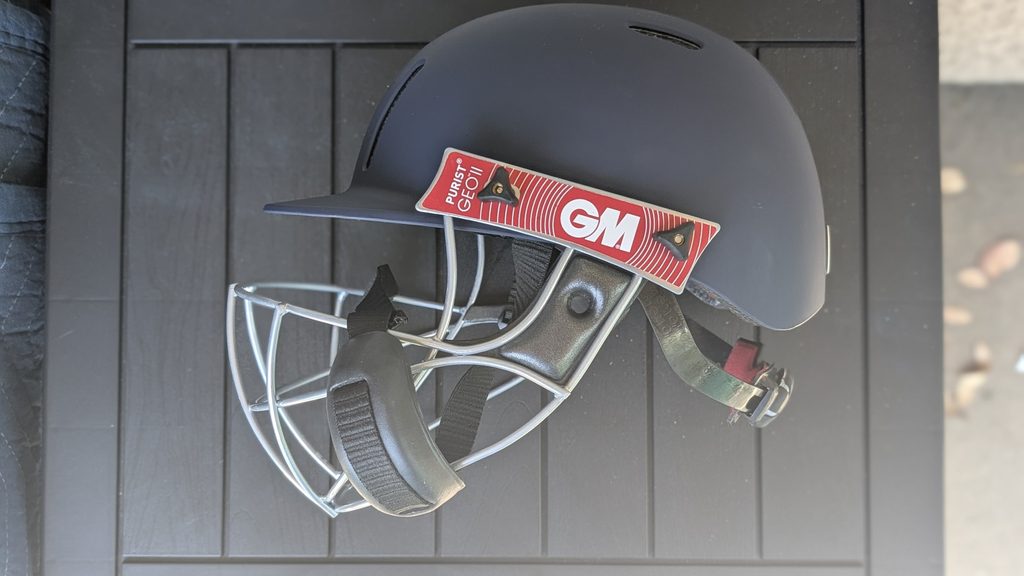 Side view of the GM Purist GEO II cricket helmet showing the geodesic steel grill design