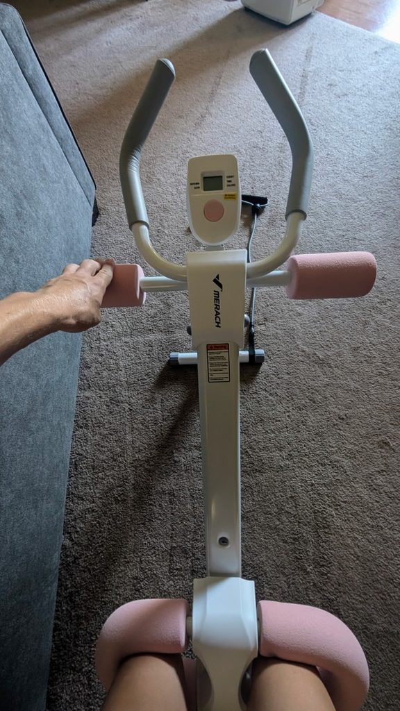 User doing crunch workout on MERACH Ab machine in pink and white