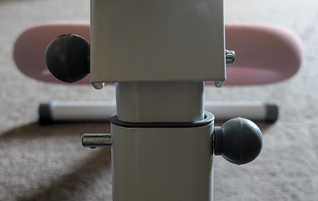 Close up of pins in MERACH ab trainer that change height or fold the machine