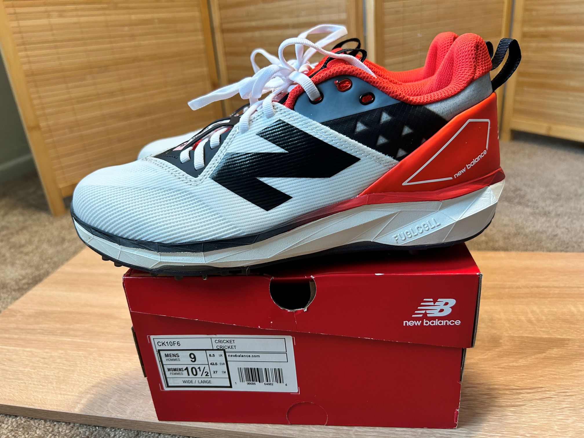 Review of the new CK10 New Balance cricket shoes in red and black set on shoe box