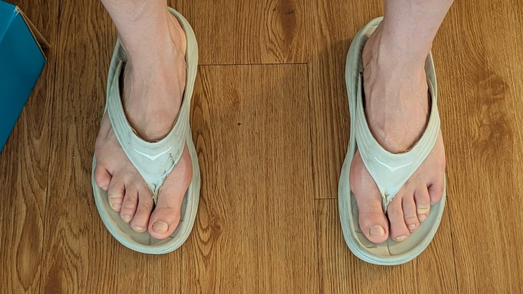 Appearance of white Ora flip flops on bare feet